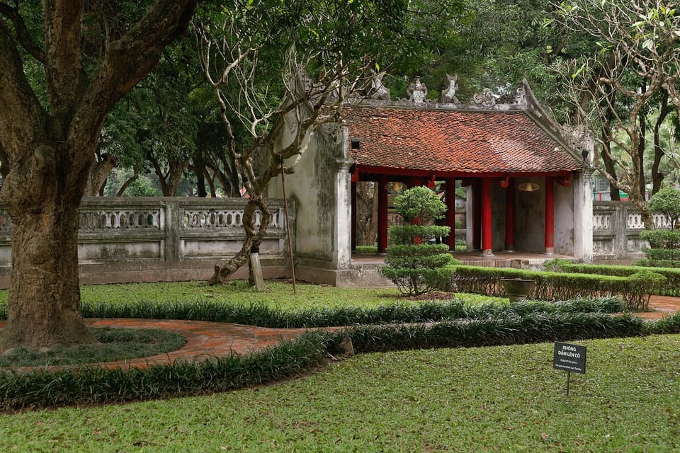 A red-roofed gate among old trees at Hanoi's Temple of Literature